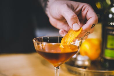 Orangezeste wird als Garnitur in den Tipperary Cocktail gegeben.