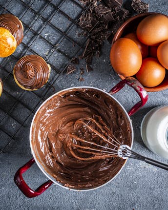 Crema pasticcera mit Schokolade in Rührschüssel mit Rührbesen