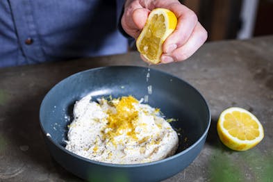 Zitrone wird über Ricotta entsaftet