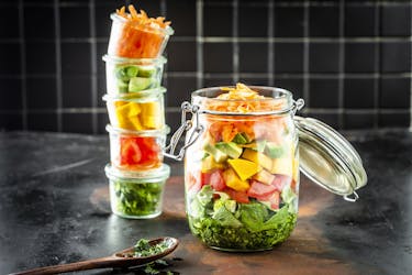 Bunter Schichtsalat in einem Einmachglas mit Deckel