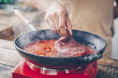 Hüftsteak für Carne alla Pizzaiola wird angebraten in Pfanne
