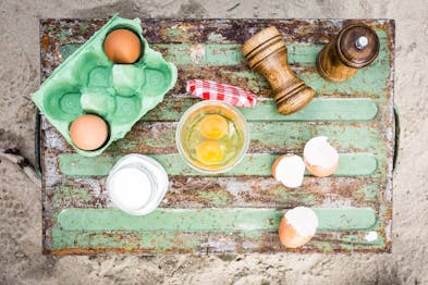 Auf einem Tisch liegen Eier, daneben liegen Salz- und Pfefferstreuer