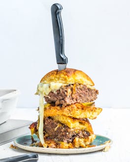 Cheeseburger-Auflauf in weißer Auflaufform und aufgetürmte Burger auf einem Teller
