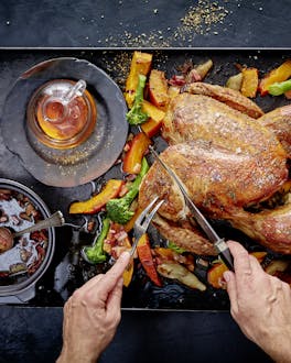 Thanksgiving-Truthahn mit Ahornsirup-Glasur wird auf einer Platte angeschnitten
