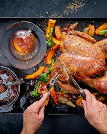 Thanksgiving-Truthahn mit Ahornsirup-Glasur wird auf einer Platte angeschnitten