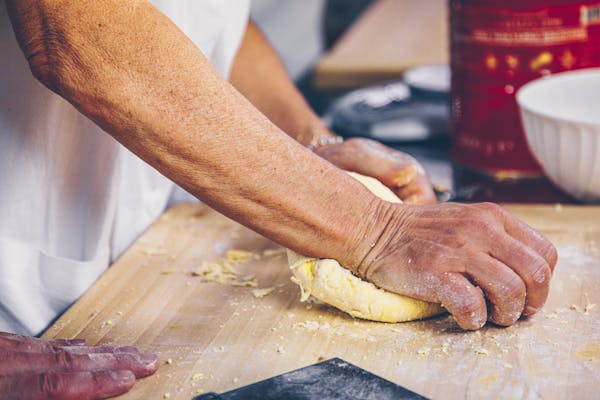 Teig für selbst gemachte Tortellini wird mit Hand durchgeknetet