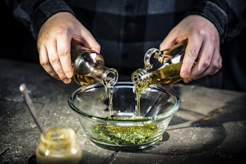 Essig und Öl mit Radieschengrün, Senf und Honig zu einer Vinaigrette vermengen.