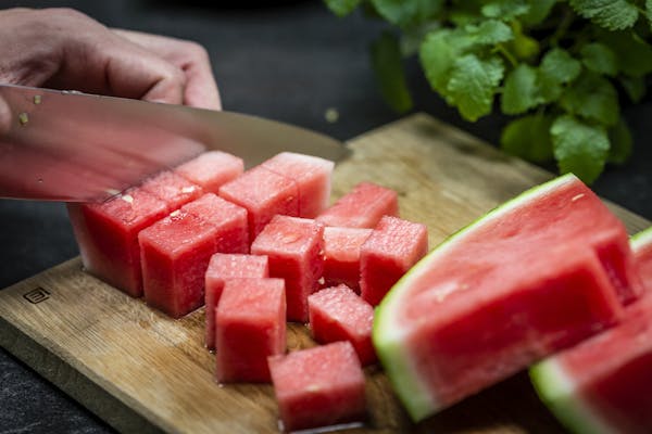 Eine geschälte Wassermelone wird in Würfel geschnitten
