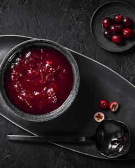 Eine Schale frische Cranberrysauce vor schwarzem Hintergrund