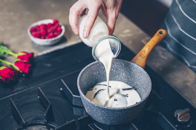 Sahne, Zucker, Vanilleschote in einem Topf aufkochen