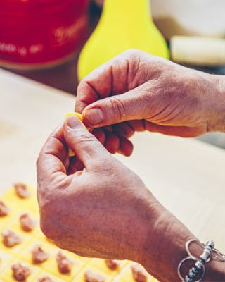 Hände formen aus Teig und Füllung Tortellini