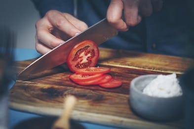 Eine große Tomate wird in Scheiben geschnitten