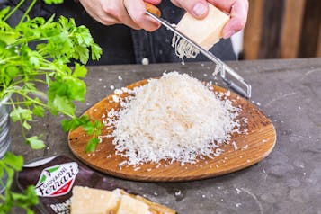 Parmigiano Reggiano auf Teller reiben