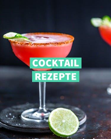 Zwei rote Cocktails im Stielglas vor dunklem Hintergrund