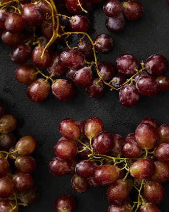 Rote Weintrauben in Nahaufnahme auf schwarzem Untergrund