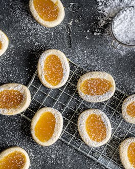 Italienische Zitronenkekse auf dunklem Untergrund mit Lemon Curd und Puderzucker
