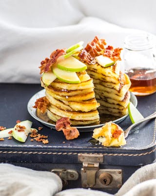 Pancakes mit Bacon und Apfel im Bett serviert