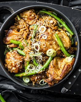 Reis, Hähnchen und Gemüse in einem schwarzen Topf