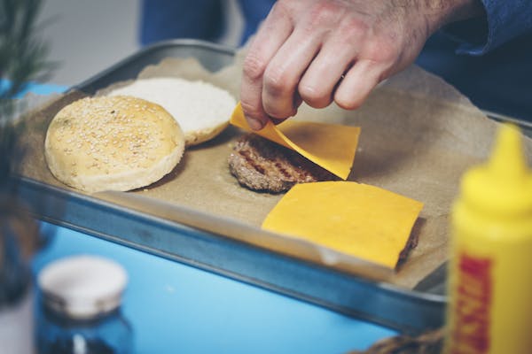 Für Cheeseburger eine Käsescheibe auf dem heißen Patty schmelzen lassen