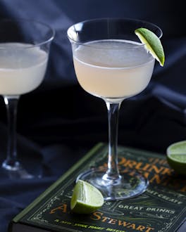 Hemingway Special Cocktail in zwei Cocktailgläsern auf einem Buch.