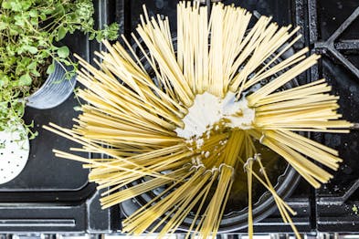 Spaghetti aufgefächert in einem Topf mit Wasser auf einem Gasherd