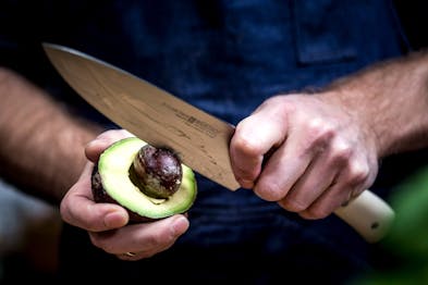 Der Avocadokern wird mit einem Messer entfernt.