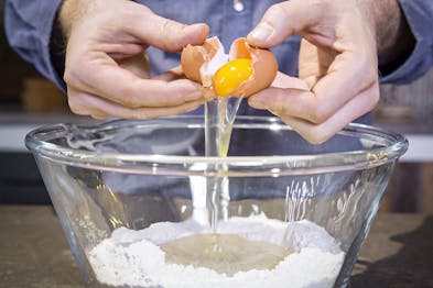 Ei wird zum teig für italienischen Apfelstrudel gegeben