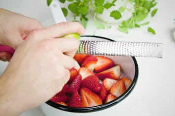 Erdbeeren und Limettenschale reiben