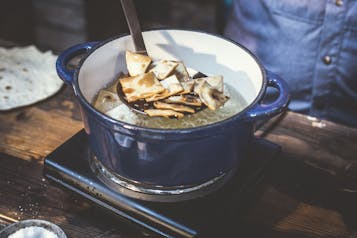 Fladenbrot-Stücke werden in einem blauen Topf mit Sonnenblumenöl frittiert