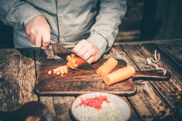 Eine Karotte wird in Würfel geschnitten.