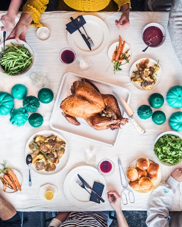 Eine Thanksgiving-Tafel mit Essen und vielen Personen am Tisch