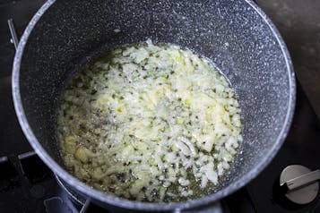 Zwiebeln werden in einem Topf in Butter angeschwitzt