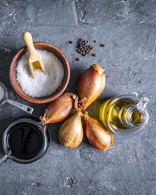 Schalotten, Olivenöl, Zucker, Salz, Balsamicoessig für Balsamico Reduktion auf dunklem Untergrund