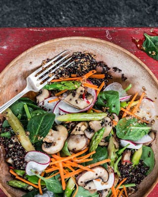 Quinoa-Salat mit Pilzen, Karotten, Spargel in einer Schüssel
