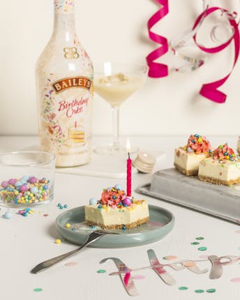 Bunte Funfetti Bites auf Tablett und Teller vor einem fröhlich dekorierten Geburtstagstisch