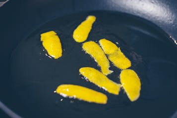Zitronenschale aromatisiert Olivenöl in Pfanne