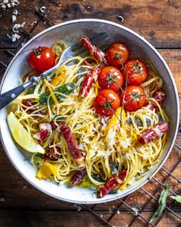 Spaghettini in Zitronensauce und Parmaschinken auf Holzuntergrund