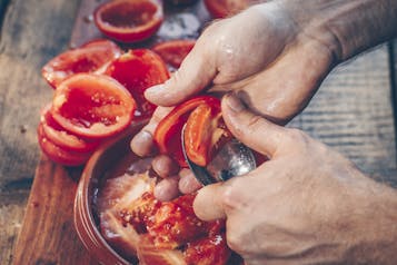 Tomaten halbieren und Kerngehäuse herauskratzen
