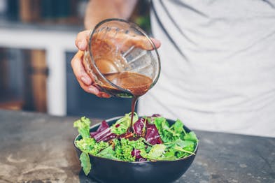 Salatdressing-auf-Salat-geben