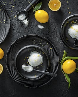 Zitronensorbet auf 3 schwarzen Tellern