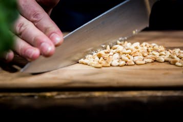 Pinienkerne für Pesto rosso werden mit Messer gehackt