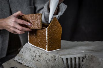 Teile des Lebkuchenhauses werden mit Zuckerguss festgeklebt
