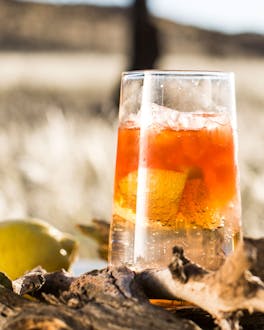 Erfrischender goldorangener Cocktail mit Whiskey, Angostura Bitters, Zitronenlimonade auf Eis.