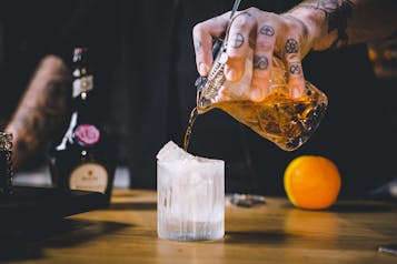 Vieux Carré Cocktail mit dem Strainer in den Tumbler geben.
