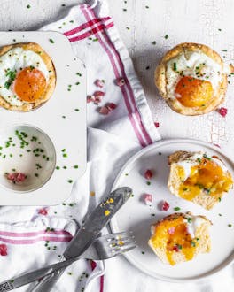 Herzhafte Muffins in Blech mit Speck und Ei auf weißem Untergrund