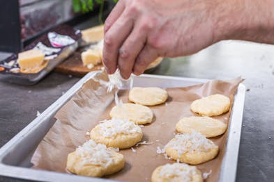 Parmesan-Cookies mit Parmigiano Reggiano bestreuen