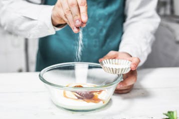 Eine Prise Salz wird auf Joghurt und Honig in eine Glasschüssel gestreut.