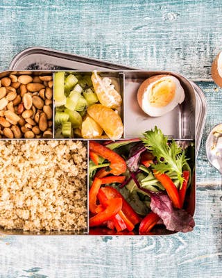 Bento-Box mit Couscous, Paprika, Eiern, Erdnüssen, Mandarinen