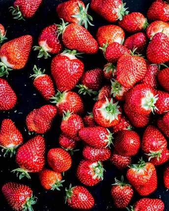 Viele frische Erdbeeren vor einem dunklen Hintergrund