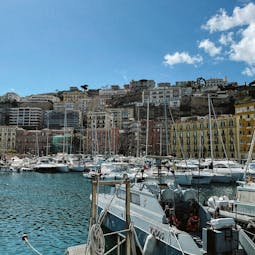 Der Hafen von Neapel mit Häusern hinter dem Meer und Booten